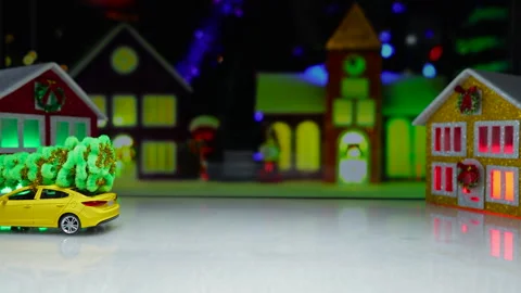 An orange car pulls up to a yellow one against the backdrop of a Christmas town Stock Footage 316221291