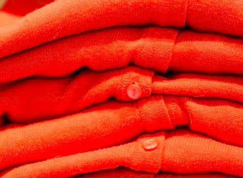 Orange Cardigans in a Stack Stock-Fotos