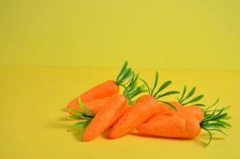 Orange carrot on a yellow background. Easter. Stock-Fotos