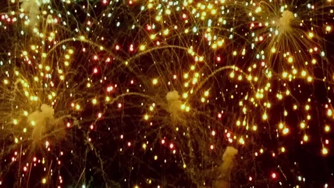 Orange cascade falling down as fireworks light up the New Year Video stock 317282170