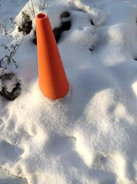 Orange caution cone covered in snow warning slip hazzard Stock Photos