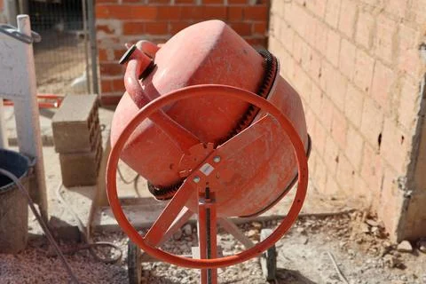 Orange cement mixer on a construction site ready to mix concrete for building Stock Photos