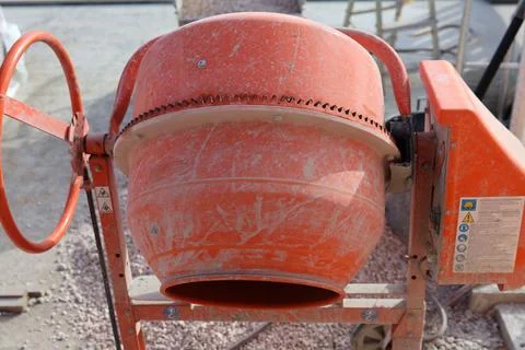 Orange cement mixer on a construction site, ready for mixing concrete Stock Photos