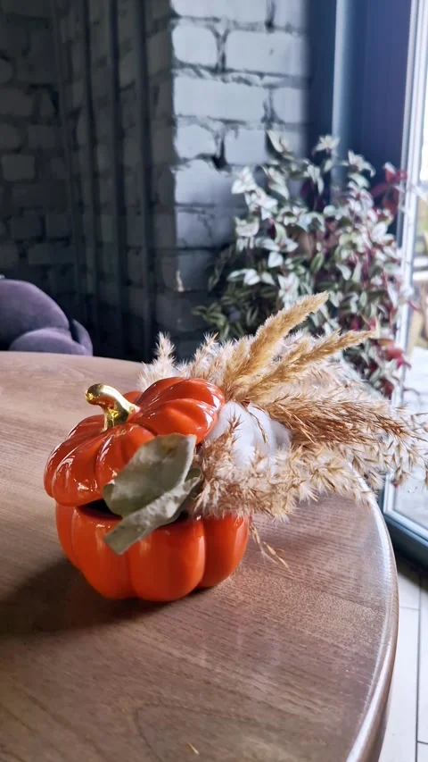 Orange Ceramic Pumpkin Vase with Dried Grass on Wooden Table Stock Footage 322541269