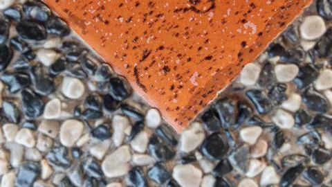 Orange Ceramic Tile and Pebble Stone Surface Contrast Stock Photos