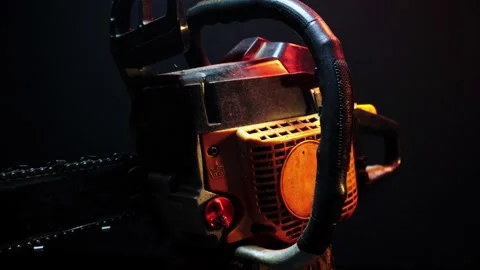 Orange chainsaw in a dark room for testing Stock Footage 331283141