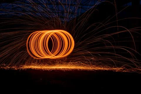 Orange circle moving light fire trails on black background. Stock Photos