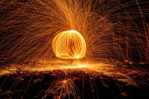 Orange circle moving light fire trails on black background. Stock Photos