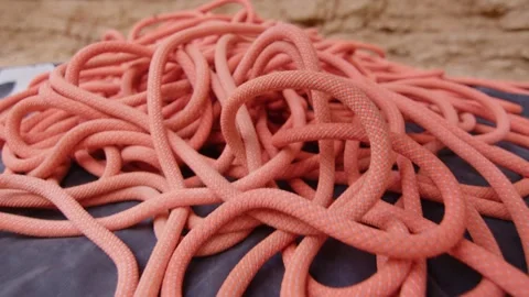 Orange climbing rope tangled on the ground at a cliff, Margalef, Spain Stock Footage 289295050