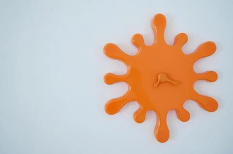 Orange clock on wall Foto stock