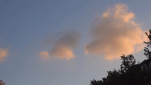 Orange clouds in the blue sky slowly move Video stock 124584400