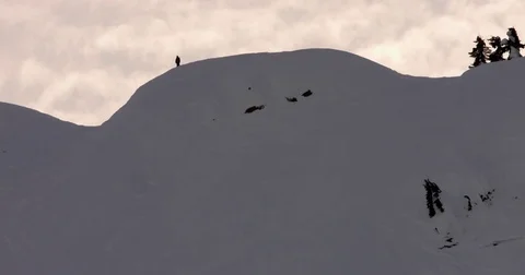 Orange clouds floating over the snow covered mountains during sunset Stock Footage 77767182