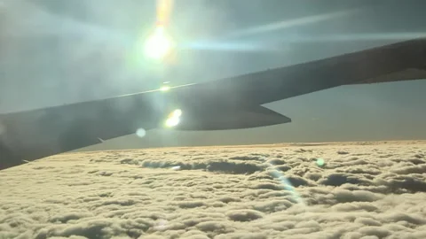 Orange clouds plane wing in the air sun flare Видео 221593666