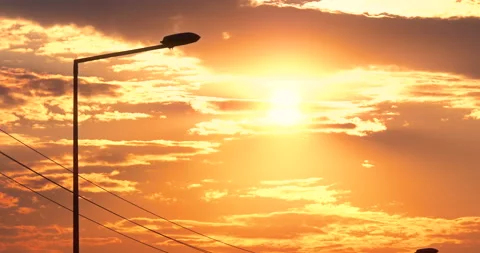 Orange Clouds Sunset in front of Lamp Post Stock Footage 141143571