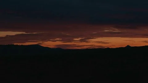 Orange cloudy dawn over silhouette of landscape Stock Footage 81919191