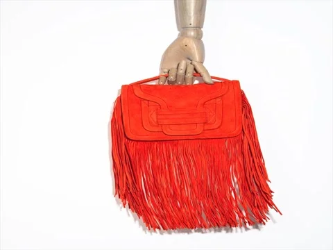 Orange clutch of suede in the hand of a dummy, moving on a white background Stock Footage 80336682
