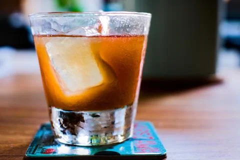 Orange cocktail with large rectangular ice cube in old fashioned tumbler Stock Photos