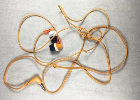 Orange color earphone on background. Stock Photos