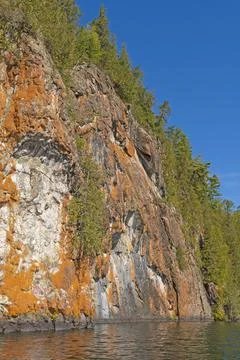 Orange Colored Cliffs High Above the Wilderness Waters Stockfoto's