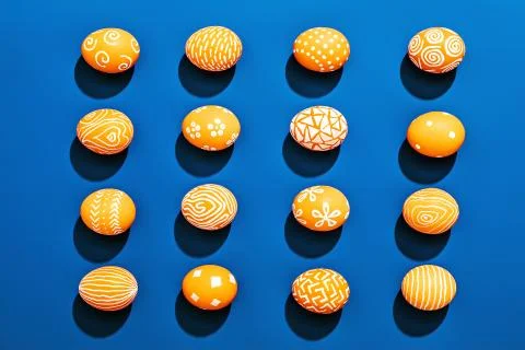 Orange colored Easter eggs pattern on contrasting blue background 스톡 사진
