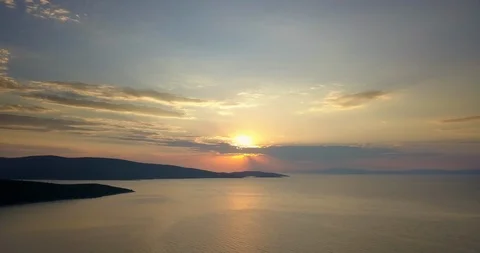 Orange colored sun behind the clouds over the sea at sunset Stock Footage 108061805