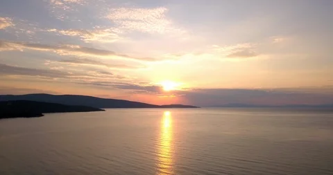 Orange colored sunset reflecting on sea surface Stock Footage 107973661