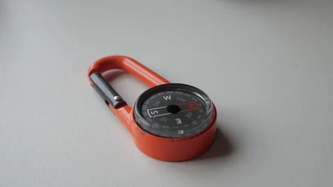 Orange Compass with Carabiner for Navigation and Outdoor Exploration Stock Footage 334579994