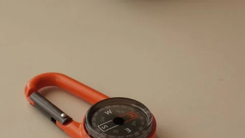 Orange Compass with Carabiner for Navigation and Adventure Stock Footage 334580417