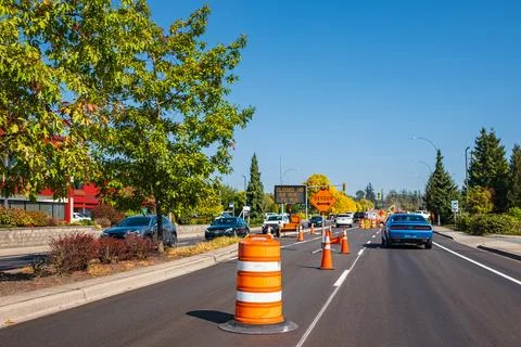 Orange cones set up to direct traffic. Construction site is repairing asphalt Stock Photos