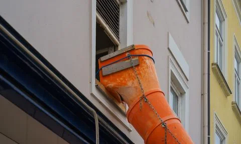 Orange Construction Debris Chute Installed in Old Building Window Stock Photos