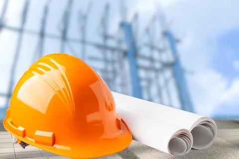 Orange construction helmet with blueprint, engineer safety concept. Stockfoto's