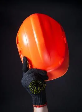 Orange construction helmet close-up. The man makes a greeting gesture Stock Photos