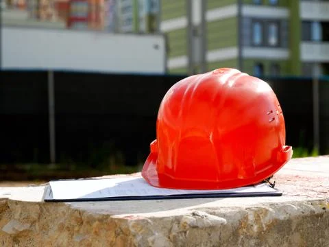 Orange construction helmet on a tablet with documents. Stock Photos