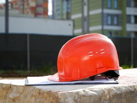 Orange construction helmet on a tablet with documents. Stock Photos