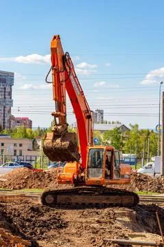Orange construction single-bucket crawler excavator in the summer Stock Photos