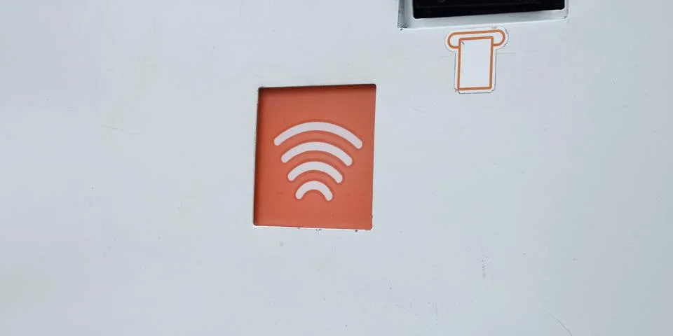 Orange contactless reader panel for plastic card on gray ATM machine Stock Photos