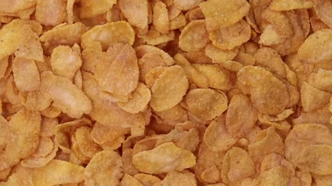 Orange cornflakes rotating closeup full frame texture background Stock Footage 329936814