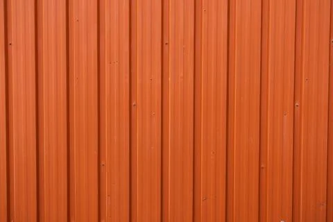 Orange corrugated metal cladding on the facade of a commercial building 库存照片