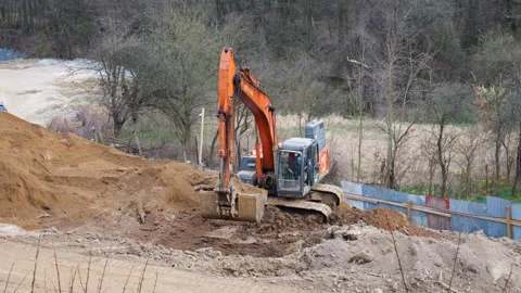 Orange crawler excavator digging earth at construction site. Stock Footage 332134272
