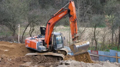 Orange crawler excavator digging earth at construction site. Stock Footage 332134992