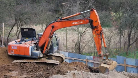 Orange crawler excavator digging earth at construction site. Stock Footage 332135129