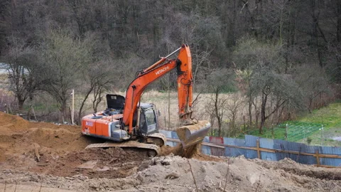 Orange crawler excavator digging earth at construction site. Video stock 332135500
