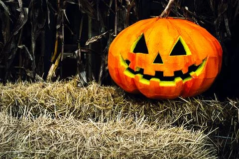 Orange creepy scary pumpkin on stack of hay or straw. Festival Halloween sp.. Stock Photos