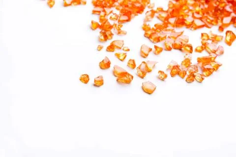 Orange crushed candy bits on white background Stock Photos