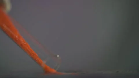 Orange crystal-like powder hangs from the test tube. Slow motion Stock-Footage 246773446