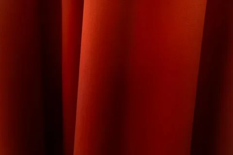 Orange curtain with a shiny surface, creating soft folds and a gentle gradi.. Stock Photos