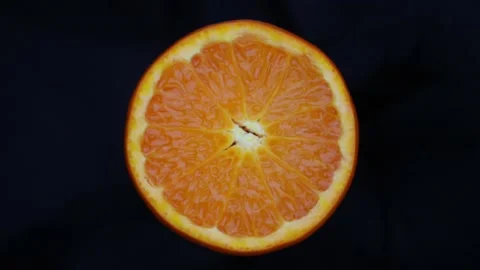 Orange cut in half rotates on a dark background Stock Footage 147675702