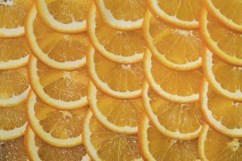 An orange cut into slices is lying on the table. Stock Photos