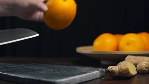 Orange is cutted by sharp knife on the rock board, slices of fresh orange, fruit Stock Footage 96192569