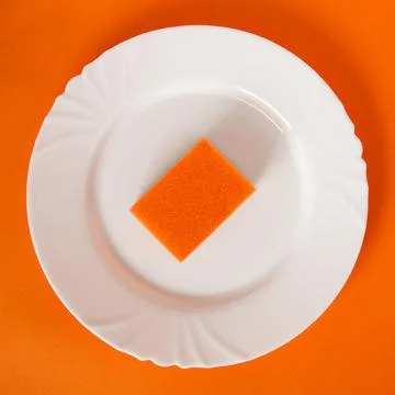 Orange dish sponge on white plate and orange background Stock Photos